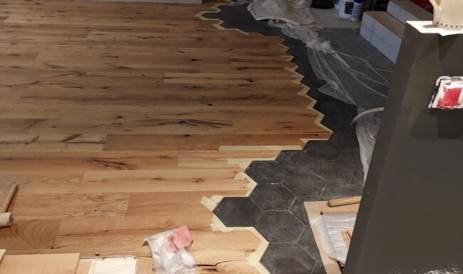 Chantier de pose de parquet en cours avec outils professionnels